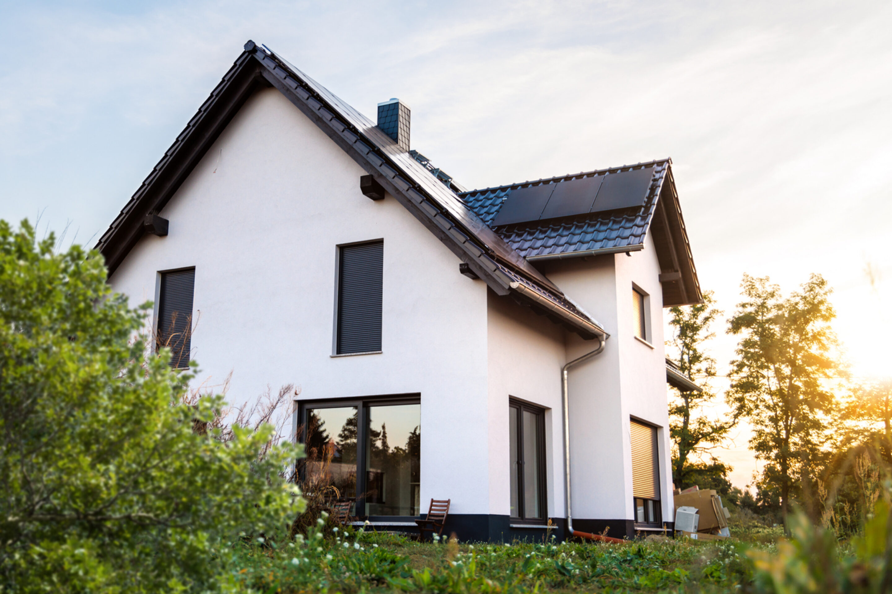 Haus mit Grünem garten und PV panele, auf dem Dach. Profitieren durch Mehrwertsteuerbefreiung mit beegy
